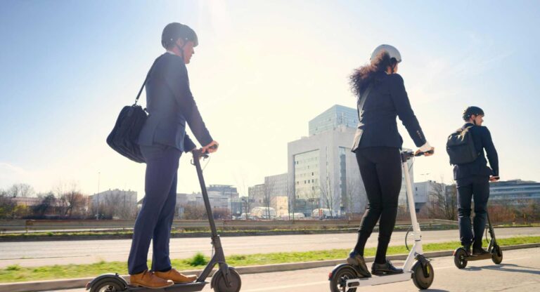 Oficinistas montando en patinete eléctrico